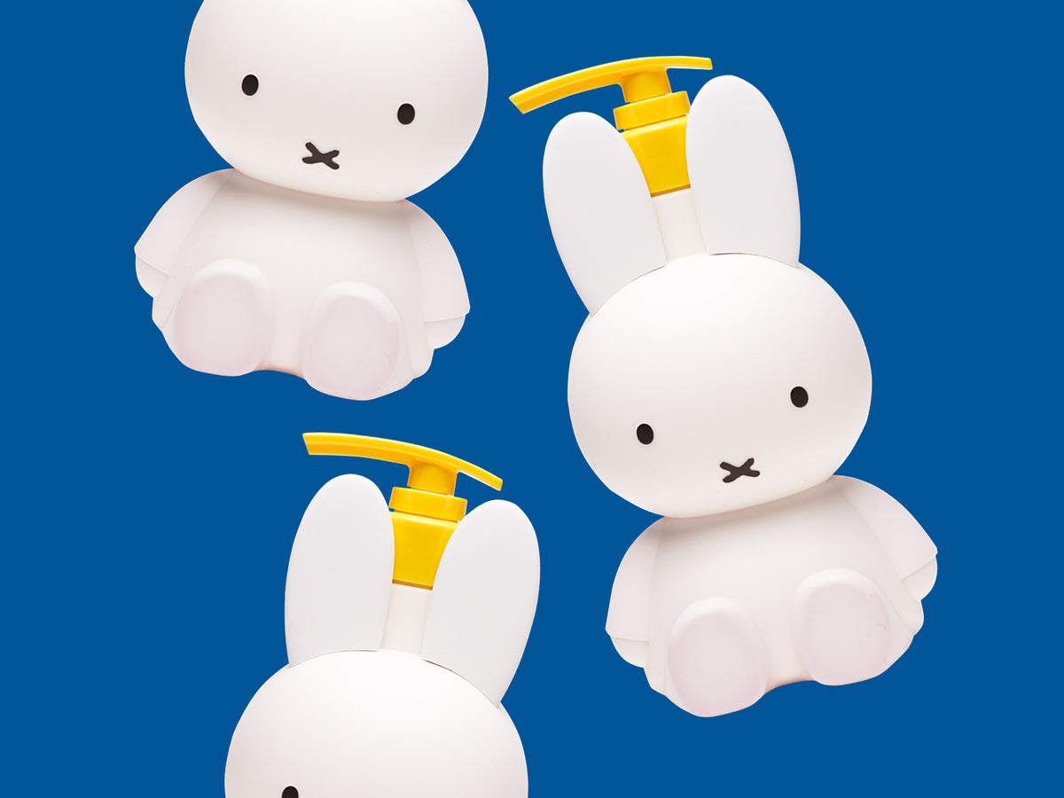Miffy Sweet Wonder body care bottles shaped like Miffy on a blue background.