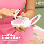 Hello Kitty Green Tea Blotting Paper — hands opening the compact and lifting the blotting puff