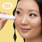 Aura Glow Highlighter — model applying highlighter to her cheekbone