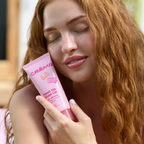 Heat Up, Glow Up Wash Off Mask — model holding the pink tube beside her face